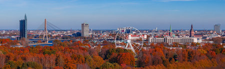 Riga skyline with Vansu Bridge, Z Towers, ferris wheel, and autumn trees