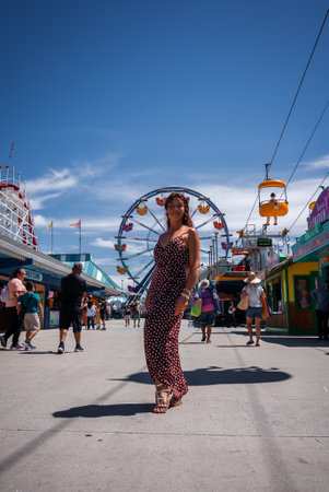 Woman in red dress on Santa Cruz Beach Boardwalk promenadeの写真素材