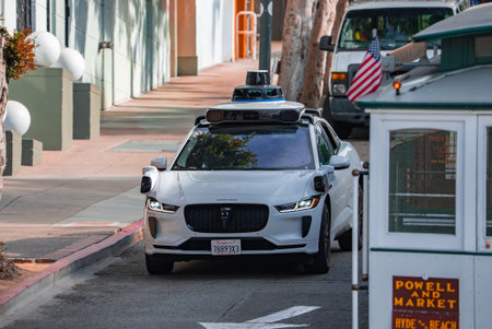 Autonomous  passes San Francisco cable car on steep streetの写真素材