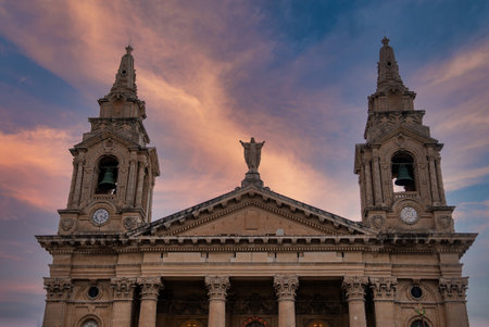 Baroque church facade with twin bell towers in Valletta at duskの写真素材
