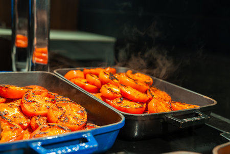 Char grilled tomato halves steam on oven trays in Mellieha, Maltaの写真素材