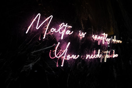 Neon cursive sign on black marble wall in Sliema, Malta at nightの写真素材