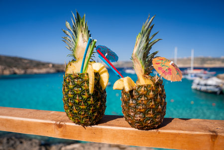 Pineapple cocktails on railing near Comino Island Blue Lagoon, Maltaの写真素材