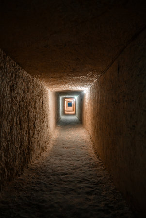 Dim stone corridor in Mellieha Malta with glowing framed exit
