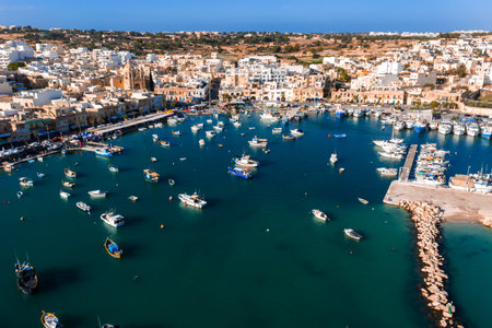 Aerial panoramic view of Marsaxlokk harbor and domed church in Maltaの写真素材