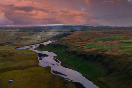Aerial river winding through Icelandic valley near Vik at duskの写真素材