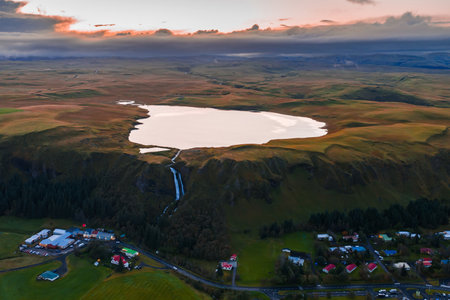 Aerial crater lake and waterfall above South Iceland plateau at duskの写真素材