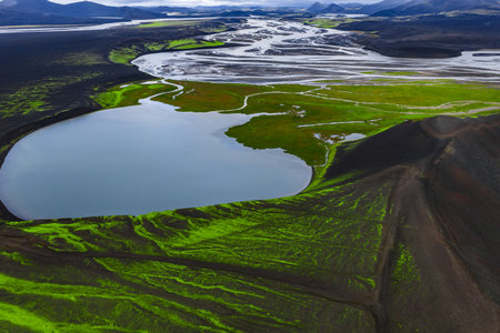 Aerial moss landscape and volcanic ridge by oval lake in Icelandの写真素材