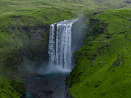 Skogafoss waterfall drops into a misty gorge in southern Icelandの写真素材