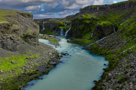 Milky turquoise river and tiered waterfalls in Sigoldugljufur canyonの写真素材