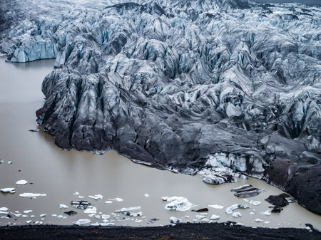 Aerial view of crevassed glacier tongue and proglacial lake in Iceland