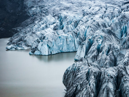 Aerial view of Icelandic outlet glacier and ash above milky lagoonの写真素材
