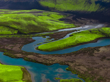 Aerial river bends through mossy volcanic highlands in Icelandの写真素材