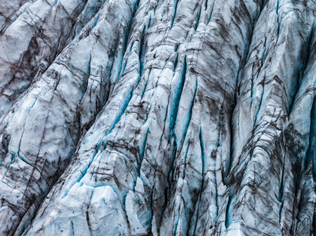 Aerial close up of crevassed glacier with ash bands in Iceland