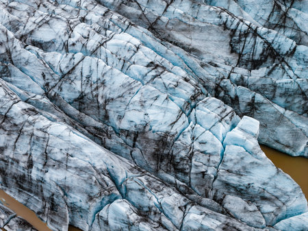 Aerial close up of blue glacier tongues with ash in Iceland lagoonの写真素材