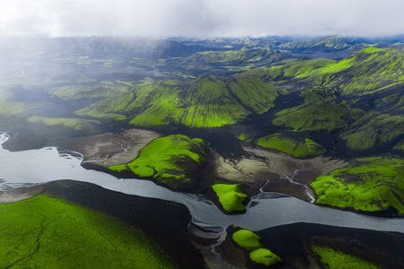 Aerial glacial river through mossy volcanic hills near Landmannalaugarの写真素材