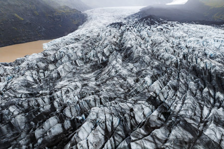 Aerial glacier with ash streaks and proglacial lake in Icelandの写真素材