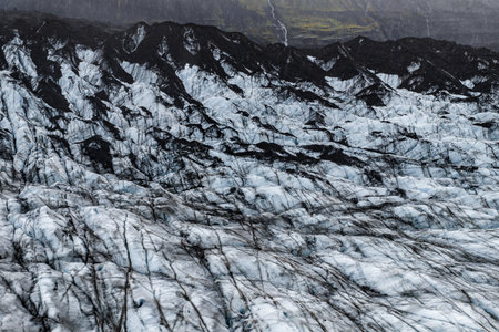 Aerial glacier with volcanic ash bands near basalt ridge in Icelandの写真素材
