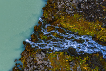 Aerial view of milky blue glacial stream over basalt in Icelandの写真素材