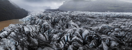 Aerial view of crevassed glacier and lagoon in southern Icelandの写真素材