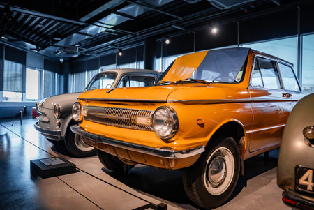 Indoor auto museum with vintage compact cars and orange microcarの写真素材