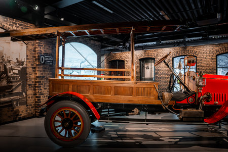 Vintage open bed fire truck displayed indoors against brick walls