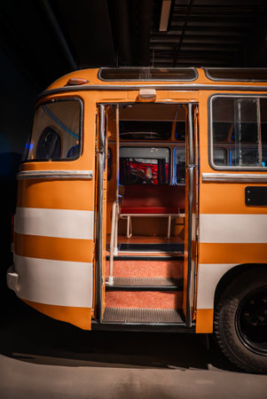 Vintage orange and white bus in museum display, door open interiorの写真素材
