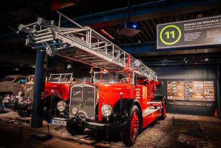 Red vintage Magirus fire engine in museum with ladder under lightsの写真素材