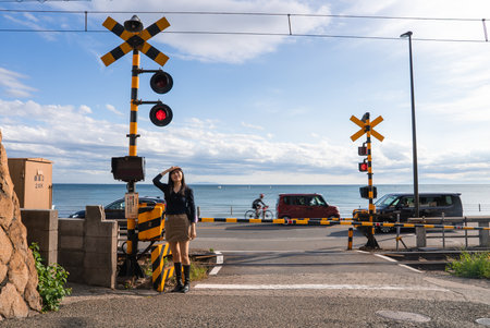 Young woman at Kamakurakokomae railway crossing by the ocean