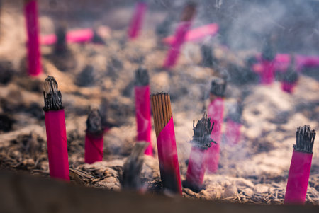 Incense sticks smolder in ash at a Tokyo temple purification cauldron