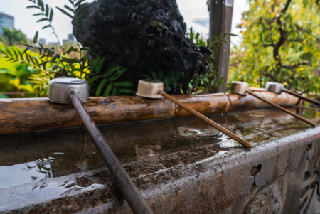Ladles on bamboo rail at temizuya purification basin in Tokyo shrineの写真素材