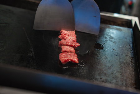 Tokyo teppan sears marbled beef slices with spatulas in close upの写真素材