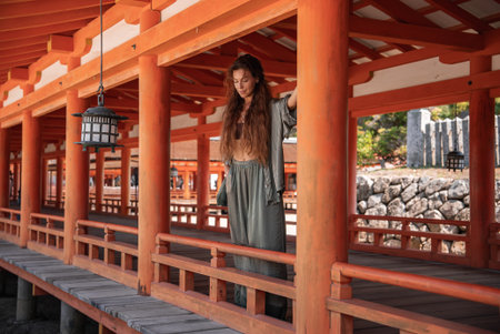 Traveler in vermilion corridor at Itsukushima Shrine, Miyajimaの写真素材