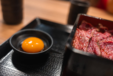 Close view of sukiyaki style beef and raw yolk in Nara restaurantの写真素材