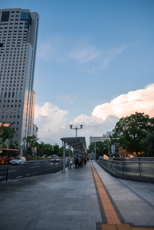 Osaka riverside street at dusk with commuters and high rise viewの写真素材