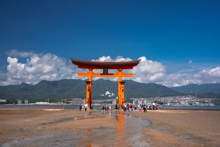 Visitors gather at the Great Torii of Itsukushima Shrine at low tideの写真素材