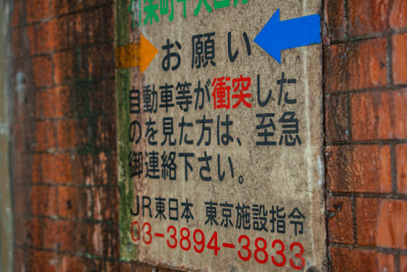 Tokyo brick wall notice sign with arrowsの写真素材