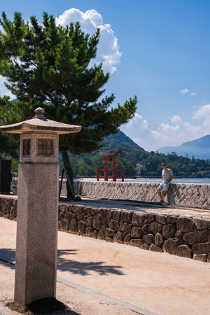 Stone lantern and Itsukushima Shrine torii from Miyajima walkwayの写真素材