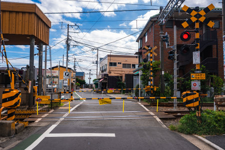 Level crossing with striped barriers in Kamakura, Japan, gates downの写真素材