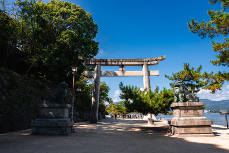 Stone torii and komainu line waterfront path to Itsukushima Shrineの写真素材