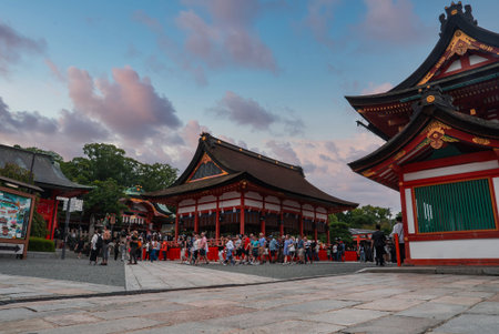 Visitors queue at Fushimi Inari Taisha shrine complex at dusk in Kyotoの写真素材