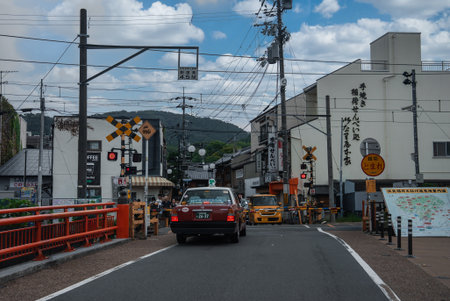 Kyoto street with taxi at railway crossing and red bridge railingの写真素材