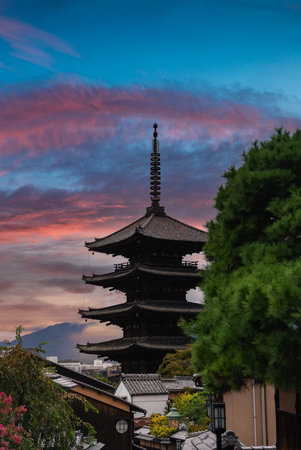 Yasaka Pagoda rises over Kyoto rooftops at sunset with hills beyondの写真素材