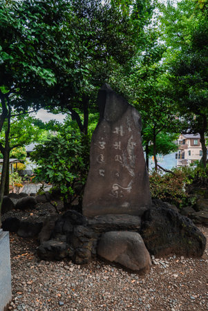 Stone stele with Japanese script in a Tokyo temple gardenの写真素材