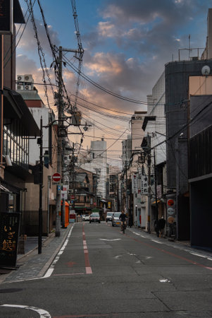 Kyoto narrow street at dusk with izakaya signs and power linesの写真素材