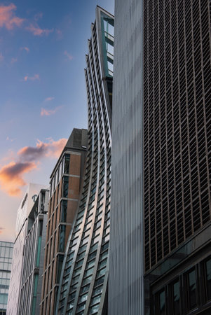 Twisting wavelike tower among Tokyo skyscrapers at sunsetの写真素材