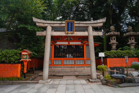 Kyoto shrine with granite torii, blue plaque, and stone toro lanternsの写真素材