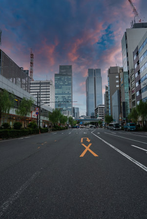 Tokyo boulevard leads to Shinjuku towers with cranes at duskの写真素材