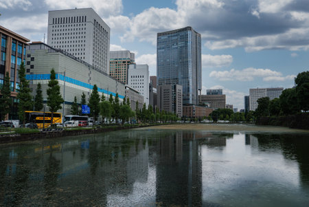 Modern high rises reflect in canal near Imperial Palace, Tokyoの写真素材