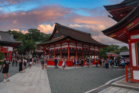 Crowd gathers at Fushimi Inari Taisha forecourt in Kyoto at sunsetの写真素材